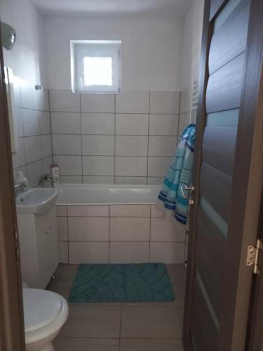 a bathroom with a tub and a toilet and a sink at City Center Flat in Odorheiu Secuiesc