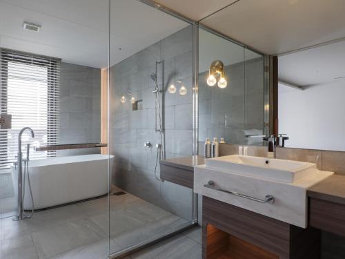 a bathroom with a sink and a shower and a tub at THE skM TOKYO HOTEL & DINING in Tokyo
