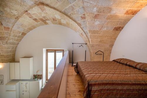 een kamer met een bed en een bakstenen muur bij Casa sul Mare - Tricase in Marina Porto