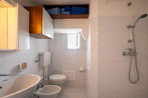 y baño con aseo, lavabo y ducha. en Casa sul Mare - Tricase, en Marina Porto