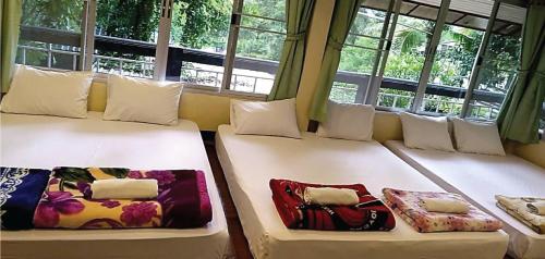 2 camas en una habitación con ventanas en Raikhruewan Resort Muaklek ไร่เครือวัลย์ รีสอร์ท, en Muak Lek