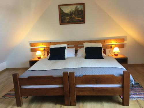 a bedroom with a large wooden bed with two lamps at Tatraview House in Veľká Lomnica