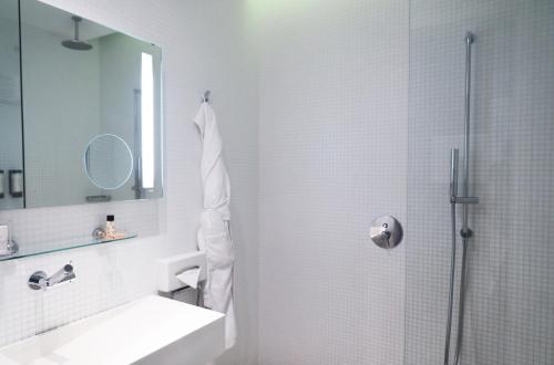 a bathroom with a shower and a sink and a mirror at Le Grand Hôtel Grenoble, BW Premier Collection by Best Western in Grenoble