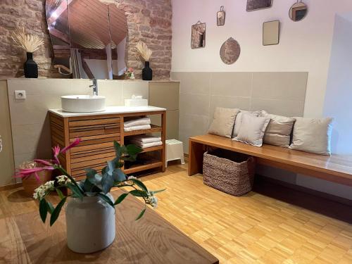 ein Bad mit einem Waschbecken und einer Bank in einem Zimmer in der Unterkunft Le Clos de Miribel in Givry