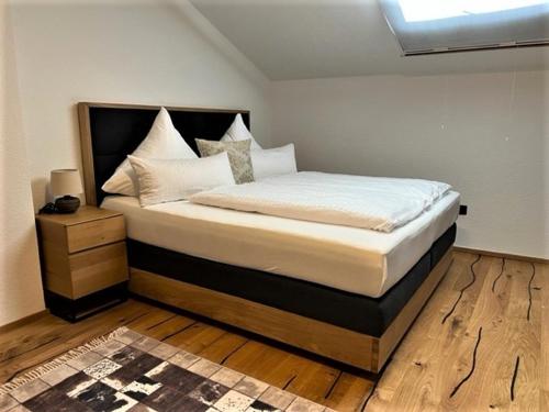 a bedroom with a large bed with a wooden floor at Zum Fischer am See ***S in Prien am Chiemsee