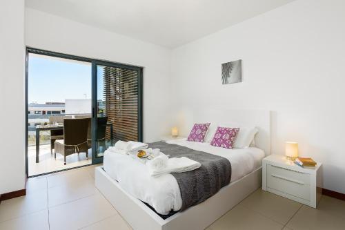 um quarto branco com uma cama e uma varanda em Marina Village Apartment em Lagos