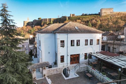 an aerial view of a white building with a castle in the background at Hotel Bineri in Gjirokastër