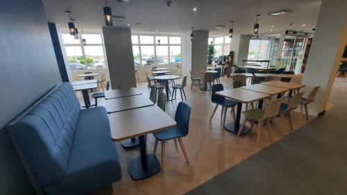 a restaurant with tables and chairs and windows at Holiday Inn Calais-Centre by IHG in Calais