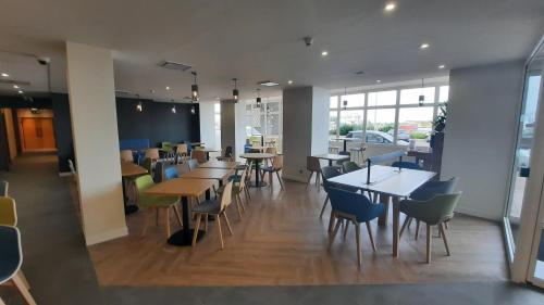 a dining room with tables and chairs in a restaurant at Holiday Inn Calais-Centre by IHG in Calais