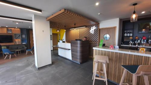 a bar in a restaurant with a counter and chairs at Holiday Inn Calais-Centre by IHG in Calais