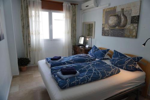a bedroom with a bed with blue sheets and a window at Apartamento del Mar - Fewo am Meer Algarrobo Costa in Algarrobo-Costa