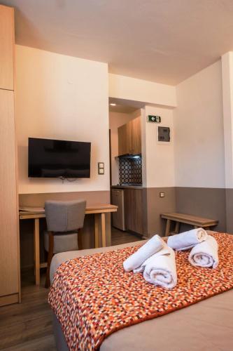 a hotel room with a bed with towels on it at Asteris Village in Gerakini