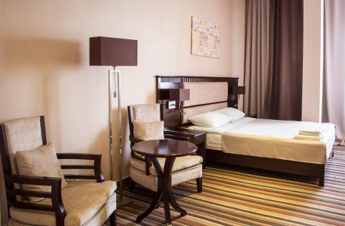 um quarto de hotel com uma cama, uma mesa e cadeiras em Guru Hotel em Ecaterimburgo