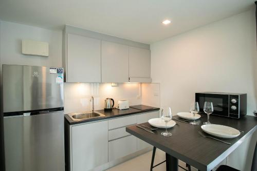 a kitchen with a table with wine glasses on it at Mantra Beach Condominium Suite - Mae Phim in Ban Tha Fat