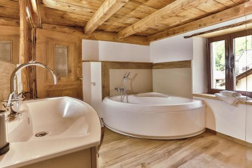 a bathroom with a large tub and a sink at Attico Adula in Castro