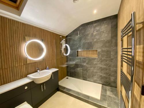 W łazience znajduje się umywalka, prysznic i umywalka. w obiekcie Granite Cottage w mieście Bridge of Cally