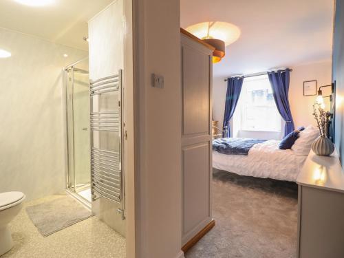 a bathroom with a toilet and a bedroom with a bed at Bodlondeb in Porthmadog