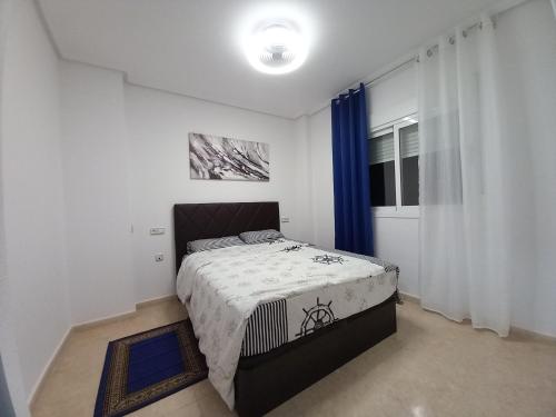 ein Schlafzimmer mit einem Bett in einem Zimmer mit einem Fenster in der Unterkunft Olga`s Apartments, 300 Meter zu Playa del Cura in Torrevieja