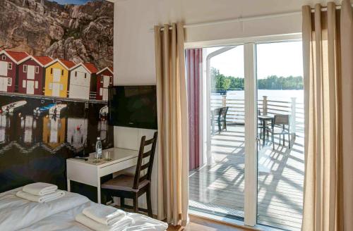 - une chambre avec un lit et un balcon avec une table et des chaises dans l'établissement First Camp Sjöstugan - Älmhult, à Älmhult