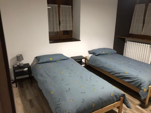 una camera con due letti, una finestra e uno specchio di Casa Milietta a Gravere