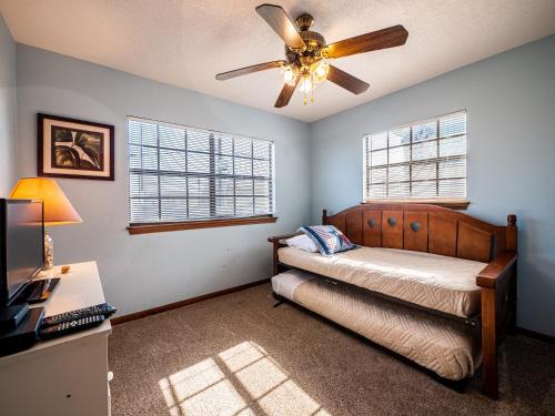 1 dormitorio con 1 cama y ventilador de techo en The Bent Rod, en Galveston