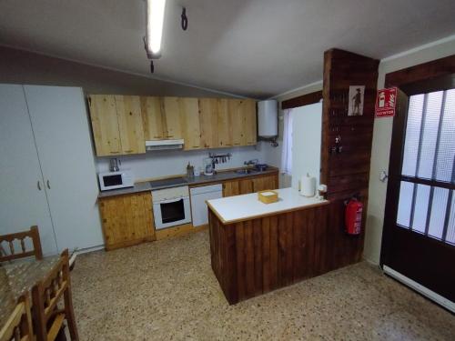cocina con armarios de madera y encimera blanca en El Cortijo del Piron, en Losana de Pirón