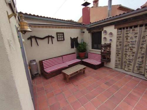 un patio con 2 bancos, una mesa y un banco en El Cortijo del Piron, en Losana de Pirón