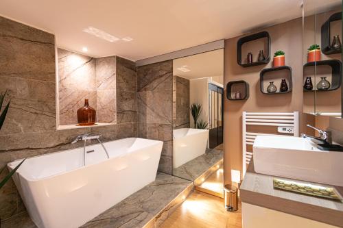 een badkamer met 2 wastafels, een bad en een bad bij Loft au bèu mitan - 50m2 in Grasse