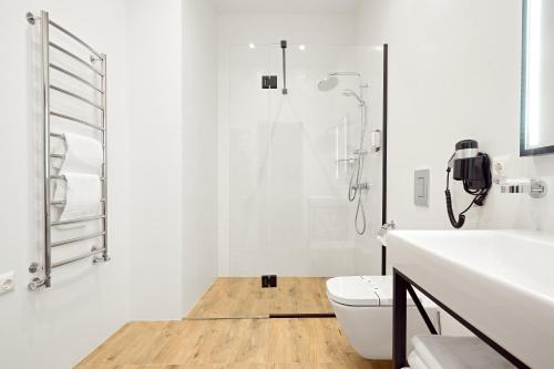 a white bathroom with a shower and a toilet at Mountain Residence 4* in Bukovel