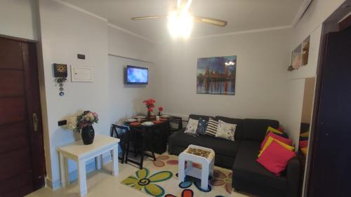 uma sala de estar com um sofá e uma mesa em Green Beach Apartment em El Alamein