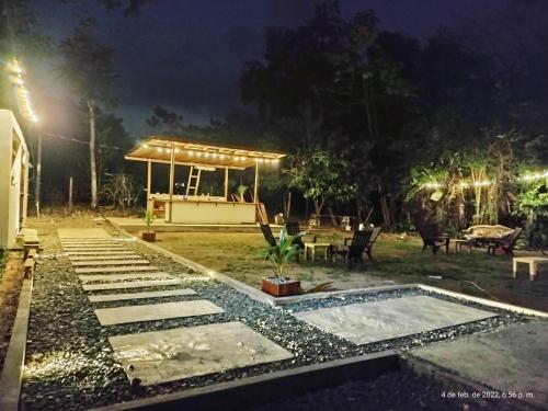 a garden at night with a pavilion in the background at Hotel Magic Capurganá in Capurganá