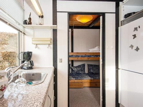 uma cozinha com um lavatório e um quarto com uma cama em Holiday home Rønde XXVI em Rønde