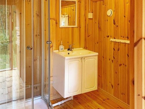 ein Badezimmer mit einem weißen Waschbecken und einer Dusche in der Unterkunft Holiday home HALDEN II in Halden