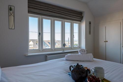 a bedroom with a white bed with a window at The White House Southwold in Southwold