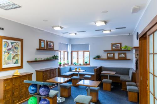 a waiting room with tables and a couch at Hotel Abácie & Wellness in Valašské Meziříčí