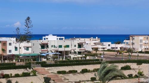 um grupo de edifícios em frente ao oceano em Green Beach Apartment em El Alamein