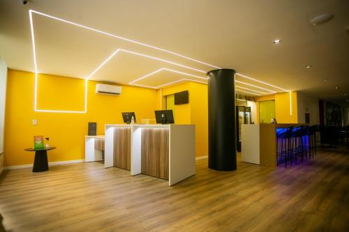 an office with yellow walls and a black pillar at ibis Styles Belem Batista Campos in Belém