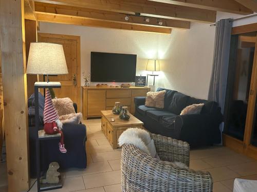 uma sala de estar com sofás e uma televisão de ecrã plano em Chalet familial em Chamoson