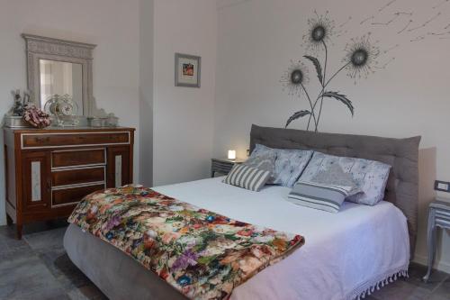 una camera con un letto e un comò con un fiore sul muro di Appartamento I Soffioni a La Spezia