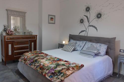 een slaapkamer met een bed en een dressoir met een bloem aan de muur bij Appartamento I Soffioni in La Spezia