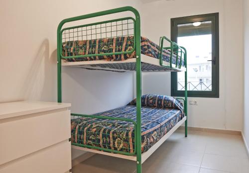 two bunk beds in a room with a window at Torredembarra in Torredembarra