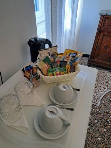 a white table with a bowl of food and a tea pot at DORA AUREA in Levanto