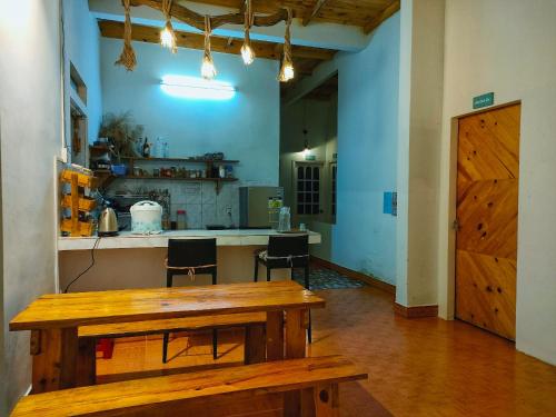 Cette chambre dispose d'une table en bois et d'une cuisine. dans l'établissement Shabbat Home Măng Đen, à Kon Von Kla