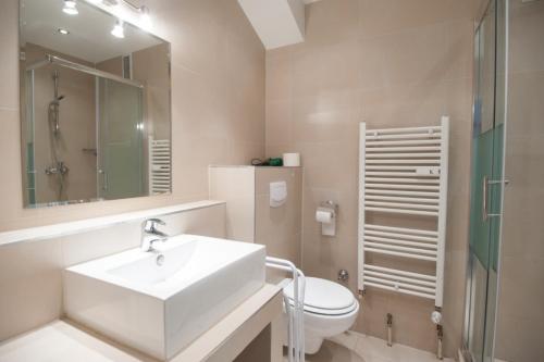 ein Badezimmer mit einem Waschbecken, einem WC und einem Spiegel in der Unterkunft City centre Anilingasse in Wien