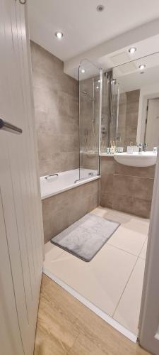 y baño con ducha, bañera y lavamanos. en Luxury 1 Bedroom Waterside Apartment in Gloucester Docks, en Gloucester