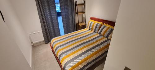 a striped couch in a room with a window at Luxury 1 Bedroom Waterside Apartment in Gloucester Docks in Gloucester