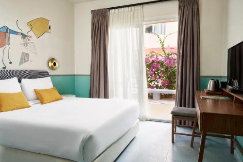 Schlafzimmer mit einem Bett, einem Schreibtisch und einem Fenster in der Unterkunft Turtle's Inn Hotel in Hurghada