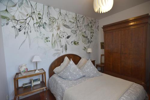 コルマールにあるLe gîte du Moulinのベッドルーム1室(花の壁画が壁に施されたベッド1台付)