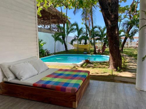 a bed sitting on a porch next to a swimming pool at JAKES ON THE BEACH in Las Peñitas
