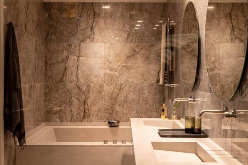 W łazience znajduje się wanna, umywalka i lustro. w obiekcie Litta Palace Milano w mieście Lainate